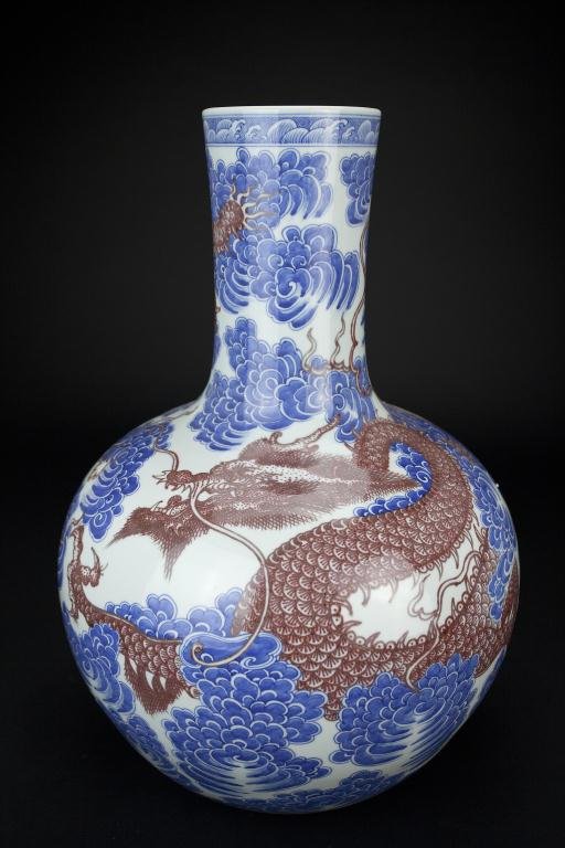 LARGE CHINESE BLUE AND IRON-RED BOTTLENECK VASE: With scrolling dragon pacing through clouds around the entirety. Mark to read Qianlong. H: 22 in.