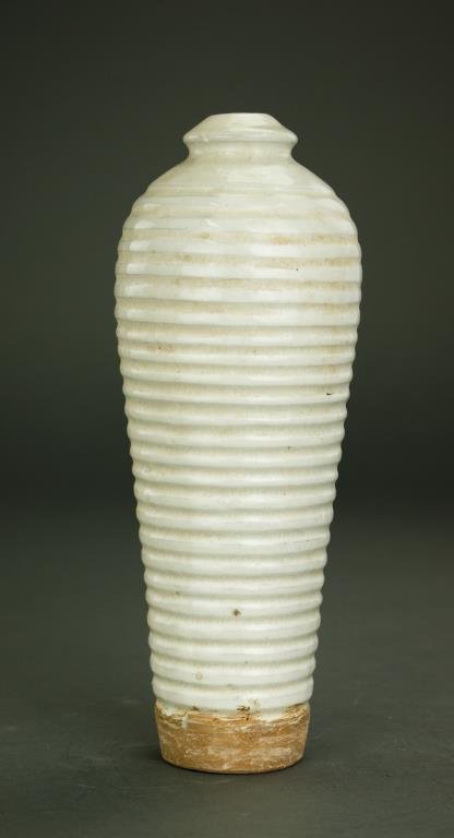ANTIQUE CHINESE WHITE OVOID VASE: With deep horizontal rib design along the entire body; conical mouth. Tapers down to unglazed base. H: 11 1/2 in.