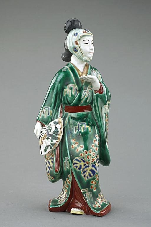 JAPANESE PORCELAIN FIGURE OF A KUTANI ACTOR: Wearing a headdress and green robe, one hand holding a fan. H: 10 5/8 in.