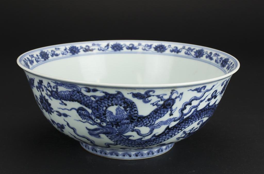 CHINESE BLUE AND WHITE PORCELAIN BOWL: Decorated with a dragon flying amidst the sky. Mark to read 'Xuande' on the base. D: 11 in.