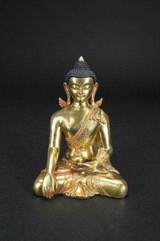 SMALL CHINESE GILTBRONZE SEATED BUDDHA: His right hand in Bhumisparsa mudra while holding a lidded vessel in the other hand. Wears large ornate earrings and a robe with a scrolling pattern border. H: 6 1/8 in.