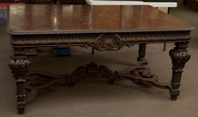 ANTIQUE DINING TABLE SET WITH TEN CHAIRS: Carved wood with checkered pattern on tabletop, with carved scrolling designs on the legs and sides of the table.