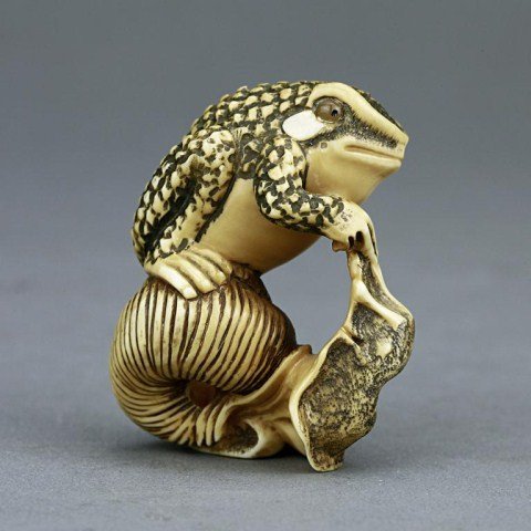 ANTIQUE CARVED JAPANESE OKIMONO: From the private collection of Mr. Paul Seigel. Figure of a frog and a snail. Stained brown color and darker details; inlaid stone eyes and cheeks on the frog. Signature on the bottom of the snail. H: