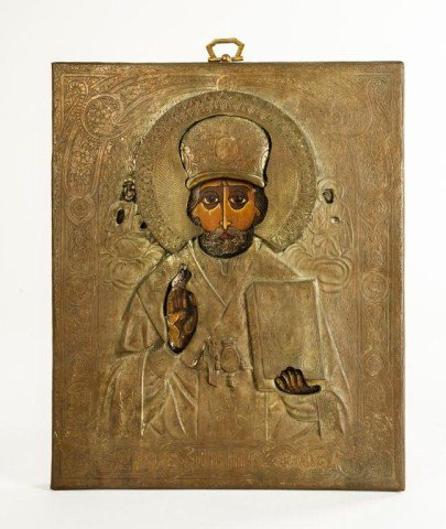 HAND PAINTED RUSSIAN ICON OF SAINT NICHOLAS: In center with painted face and hands, holding gospel book with reticulated halo. Gilt painted background and scripting filial designs around border. H: 9 3/4 in. L: 8 1/8 in.