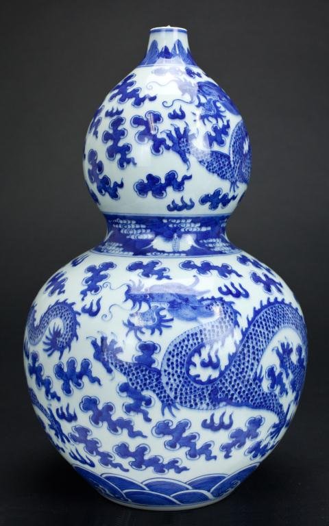CHINESE DOUBLE GOURD BLUE AND WHITE DRAGON VASE: Painted with cloud and dragon in bright cobalt blue glaze all over the vase with double ring mark under the glaze. H: 15 1/4 in.