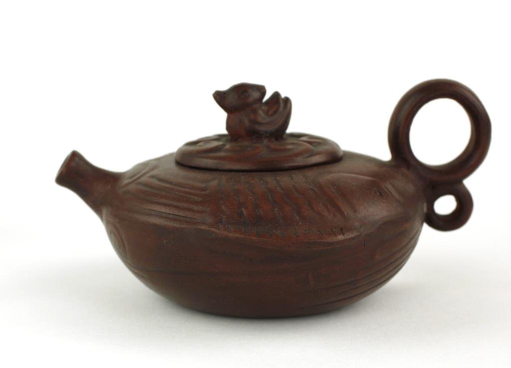 CHINESE CLAY TEAPOT WITH COVER: Of a fish design with a duck on top. Mark on the base and a mark under the cover. H: 3 5/8 in.