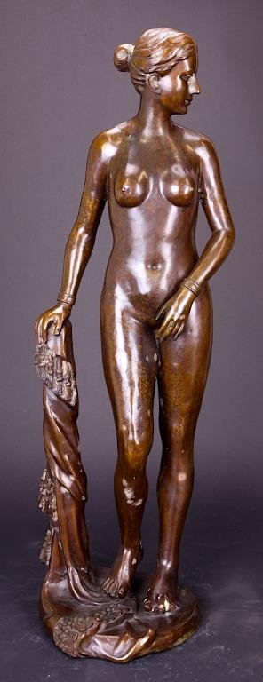 EUROPEAN BRONZE STATUE OF A WOMAN: Modeled as a standing, naked lady, with hair tied up in a knot and elegantly leaning on a tree trunk with the right arm. H: 29 1/4 in.