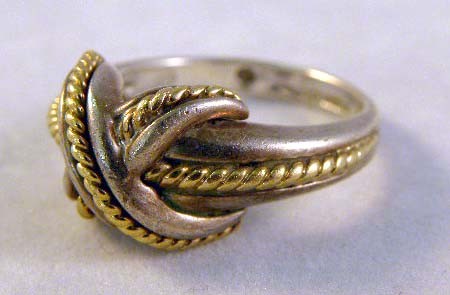 A TIFFANY LADIES STERLING SILVER RING with central: A TIFFANY LADIES STERLING SILVER RING with central knot design and gold rope detail; 4.5 dwt.