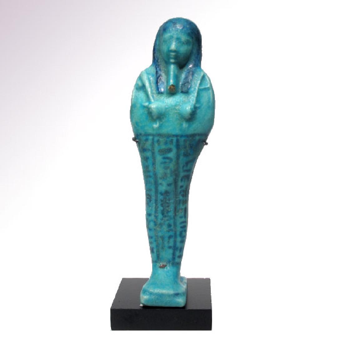 Large Turquoise Faience Shabti, Egypt, 30th Dynasty: Large Turquoise Faience Shabti, Egypt, 30th Dynasty, Ptolemaic Period, c. 380-30 B.C.A large bichrome turquoise glazed composition shabti, mummiform, holding a pick and hoe, with details in dark blue
