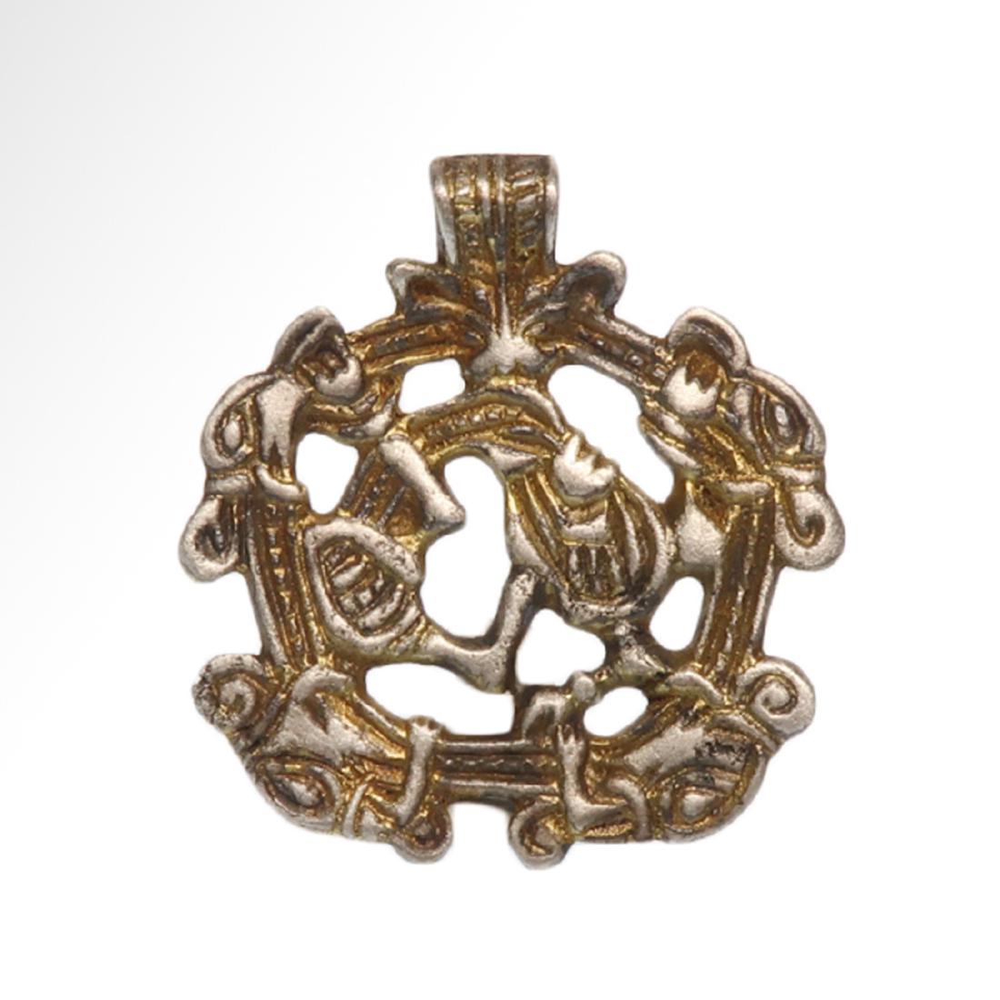 Viking Gilt Gripping Norse Wolves Pendant, c. 10th -: Viking Gilt Gripping Norse Wolves Pendant, c. 10th - 11th Century A.D. A Borre-type concave-section pendant with integral suspension loop, the ope-work plaque with three-band border and four beast-hea