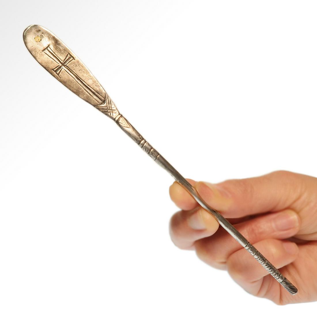 Early Byzantine Silver Spatula with Cross, c. 6th: Early Byzantine Silver Spatula with Cross, c. 6th Century A.D. Oval spatula plate engraved with a cross and inlaid with a dot of gold. Round sectioned handle with fine engravings. Size:17.5 cm L - 6 7