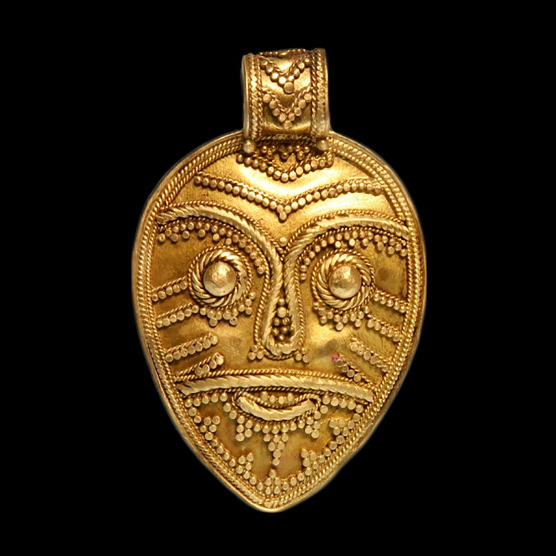 Viking Filigree Gold Pendant with Norse God Head, c.: Viking Filigree Gold Pendant with Norse God Head, c. 10th Century A.D. Egg shaped with wide loop, worked in filigree with the face of a Norse God. Size:4.8 cm L - 1 7/8 inches (including loop) Materia