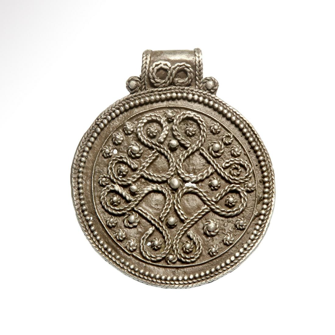 Viking Silver Pendant with Interlaced Filigree, c.: Viking Silver Pendant with Interlaced Filigree, c. 10th-12th century A.D. Silver disc pendant with integral loop, granulated border surrounding a panel with filigree ropework loops and granules with f