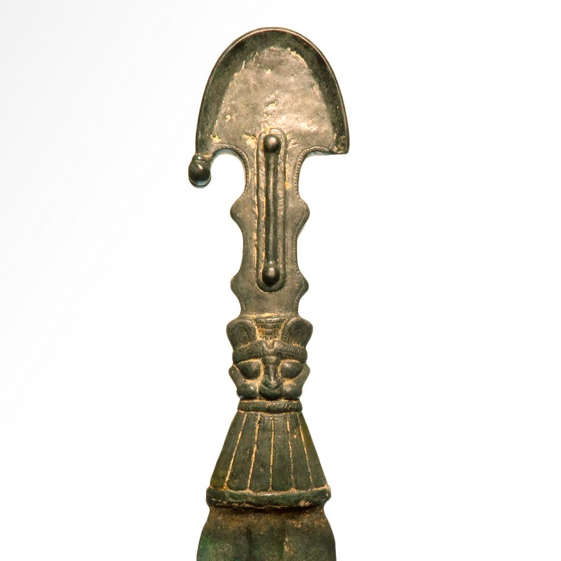 Elamite Bronze Sword with Deities, 2nd Millennium B.C.: Elamite Bronze Sword with Deities, 2nd Millennium B.C. Bifacial handle in the form of facing heads of deities with the beard forming the sword guard and a segmented part forming the headdress or crown