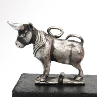 Roman Silver Bull, c. 2nd-3rd Century A.D.: Roman Silver Bull, c. 2nd-3rd Century A.D.Standing bull, long curving horns, tail resting on his back. Excellent face details and applied mane. Loop at the top for suspension.Size:3.2 cm L - 1 5/16