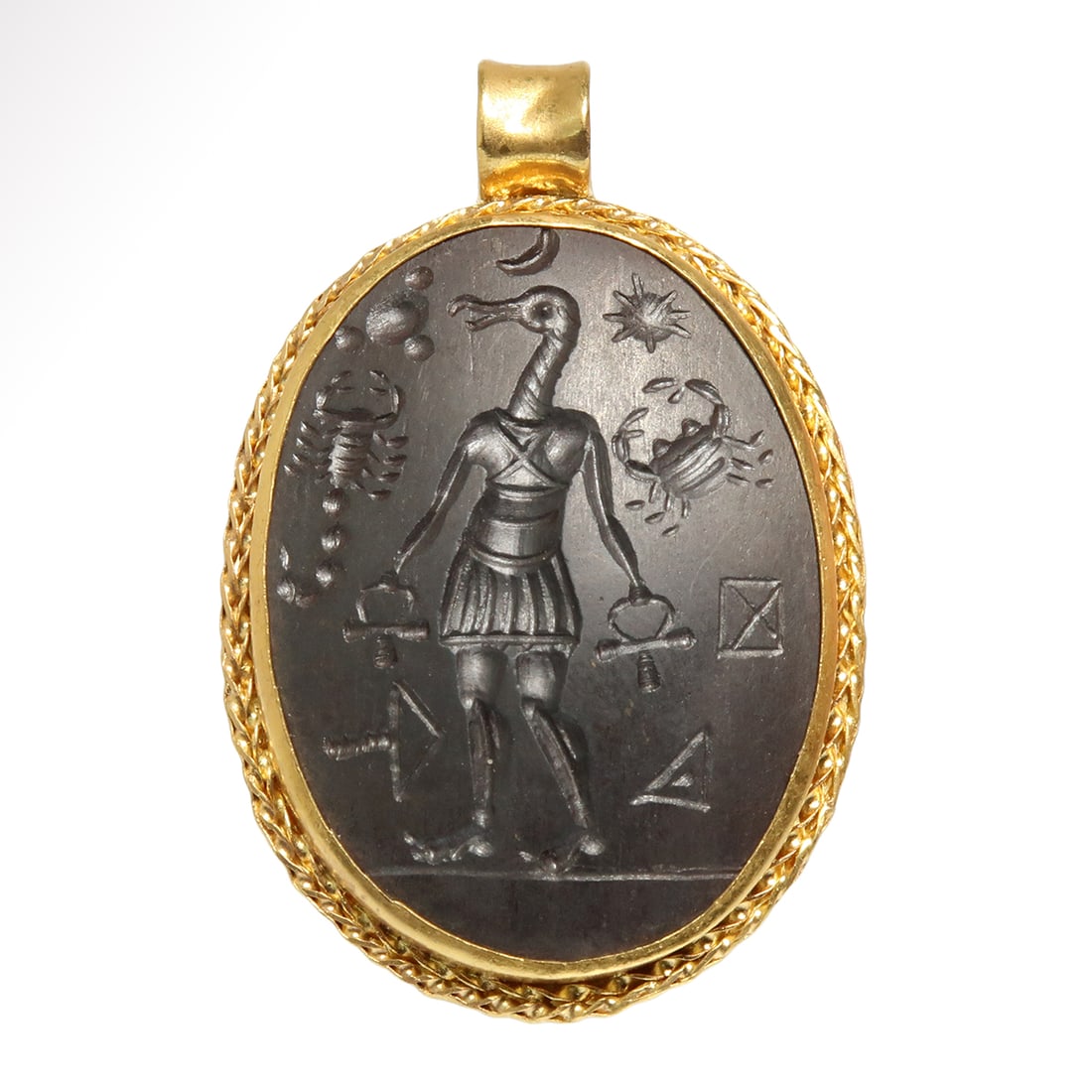 Gnostic Hematite Intaglio with Deity and Astrological Symbols, c. 2nd-4th Century A.D.: Gnostic Hematite Intaglio with Deity and Astrological Symbols, c. 2nd-4th Century A.D.Oval black hematite Gnostic intaglio engraved with the figure of an Egyptian deity, holding the ankh sign in both