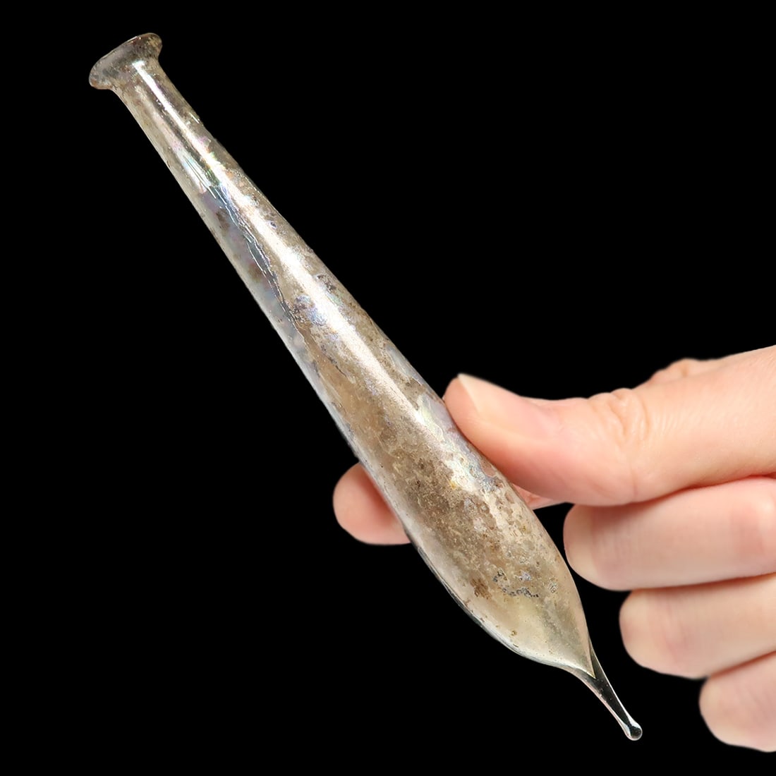 Roman Glass Long Phial, c. 1st Century A.D.: Roman Glass Long Phial, c. 1st Century A.D.Clear glass phial with long neck swelling, everted at the rim, the base tapering to an elongated point, with attractive multicolour rainbow iridescence.Size: