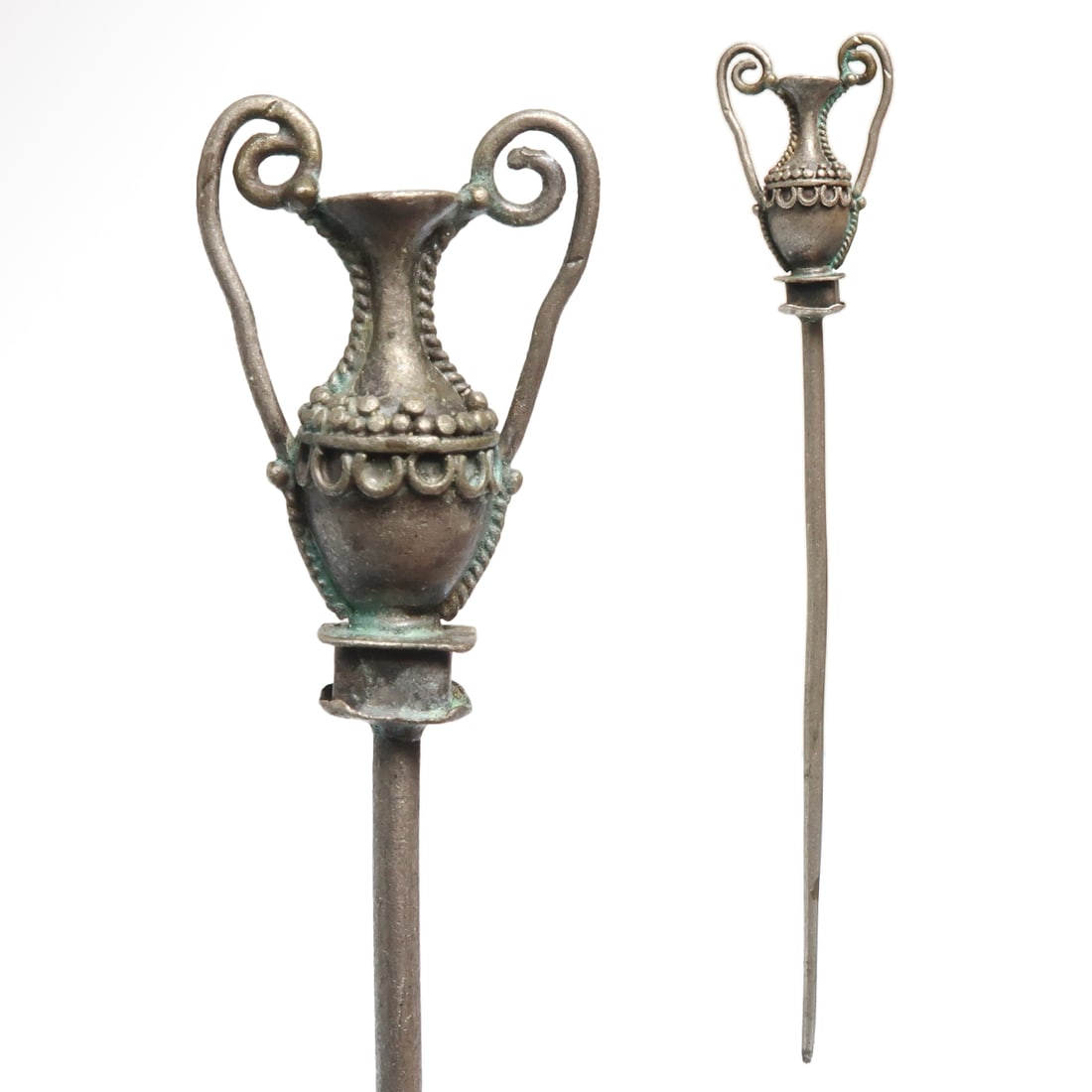 Roman Ornamental Silver Pin with Amphora, c. 2nd Century A.D.: Roman Ornamental Silver Pin with Amphora, c. 2nd Century A.D.Long thin solid silver pin, the top cast in the shape of an amphora, fluted body standing on a square pedestal, two looped handles, the bod
