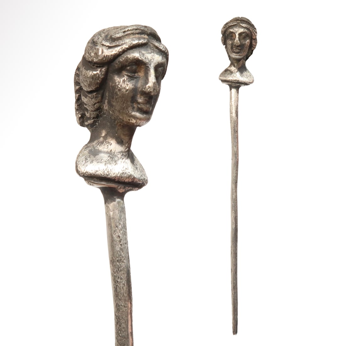 Roman Silver Pin Surmounted by the Bust of Venus, c. 2nd Century A.D.: Roman Silver Pin Surmounted by the Bust of Venus, c. 2nd Century A.D.Long pin surmounted by an elegant bust of Venus. Exquisite details of the face and hair. Size:10.4 cm L - 4 1/16 inches Material:Si