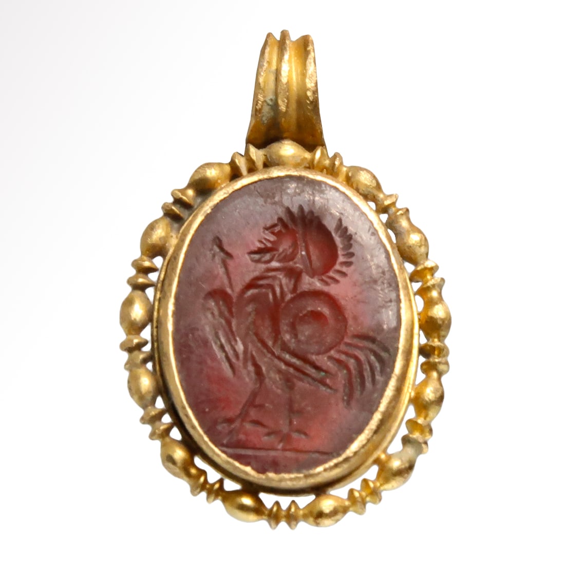 Roman Pendant with Cornelian Intaglio with Rooster/Soldier Helmeted Head, c. 2nd Century A.D: Roman Pendant with Cornelian Intaglio with Rooster/Soldier Helmeted Head, c. 2nd Century A.DOval red intaglio engraved with a hybrid creature depicted in profile facing left, the body of a rooster and