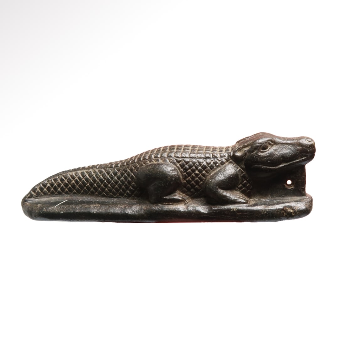 Egyptian Steatite Crocodile Amulet, c. 900-700 B.C.: Egyptian Steatite Crocodile Amulet, c. 900-700 B.C.Naturalistically depicted, the long triangular head with raised bulging eyes, the back and tail with scales rendered by hatching, perforated horizont