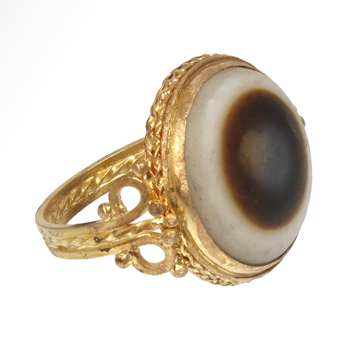 Roman Gold Ring with Agate Protective Eye Cameo, c. 2nd Century A.D.: Roman Gold Ring with Agate Protective Eye Cameo, c. 2nd Century A.D. The cast ring with filigree scrolls decoration on the shank, the thick-walled and hollow bezel set with a round banded agate of whi