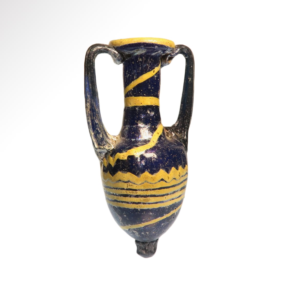 Greek Core-Formed Glass Amphoriskos, c. 3rd Century B.C.: Greek Core-Formed Glass Amphoriskos, c. 3rd Century B.C. Blue glass core-formed amphora with yellow trailing combed into zigzag and encircling lines pattern, applied blue handles and knob base. Blue s
