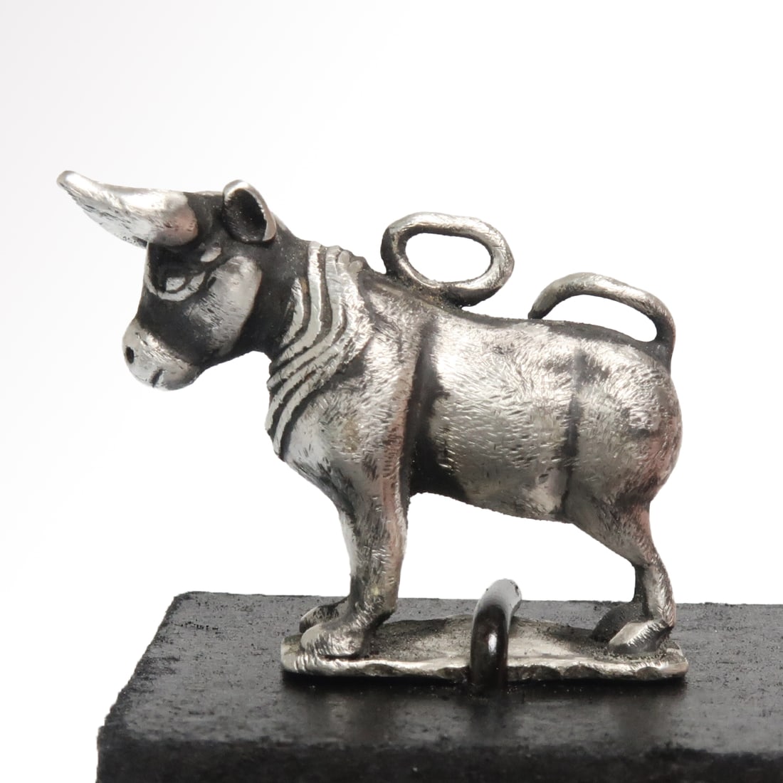 Roman Silver Bull, c. 2nd-3rd Century A.D.: Roman Silver Bull, c. 2nd-3rd Century A.D. Standing bull, long curving horns, tail resting on his back. Excellent face details and applied mane. Loop at the top for suspension. Size:3.2 cm L - 1 5/16 