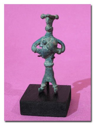 Elamite Mother Goddess Bronze Figure, c. 2200-2000 B.C.: Elamite Mother Goddess Bronze Figure, c. 2200-2000 B.C. Wearing long skirt held with belt, thick beads necklace, bracelets and a crown, bird like facial features, holding a baby to her breast. Size:7 