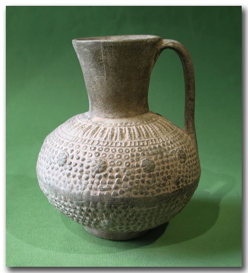 Unglazed Moulded Pottery Jug, Syria, c. 12th Century: Unglazed Moulded Pottery Jug, Syria, c. 12th Century A.D. Decorated with three bands of rosettes surrounded by dots. Size:15.3 cm H - 6 inches Material:Terracotta Culture:Syria, c. 12th Century A.D.