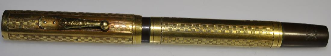 Waterman's No. 0552 Gold Overlay Gothic Pen: Circa 1925, Lever-fill (hard sac), black hard rubber, Ideal heart-vent nib, cartouche is not engraved, traces of ink visible, usage and wear, loss of plating along the clip and rim of the cartouche, 5