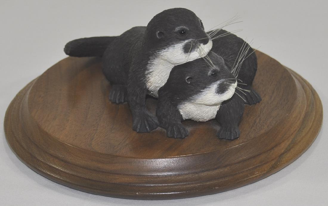 Rosalyn Leach Daisey Otter Carving: Carved and painted wood, mounted on a circular, molded walnut base, signed, circa 1989, 3.5 in. x 7.5 in. overall.