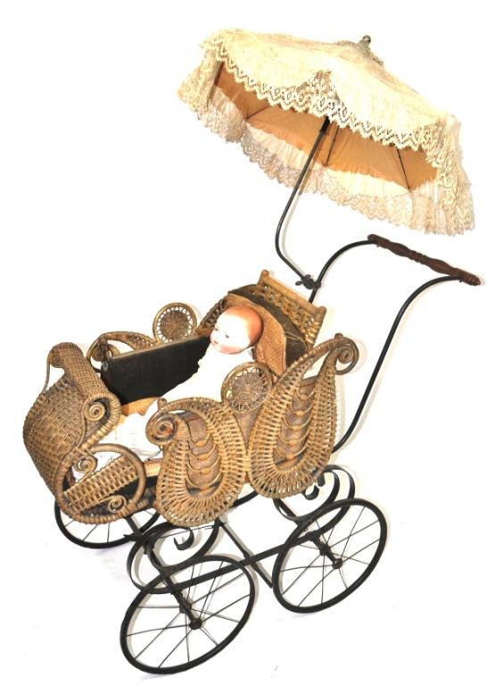 Piel Brothers Baby Carriage, Indianapolis: Sleigh-shaped carriage with paisley-shaped sides, ornate and extravagant, with attached parasol; paired with a Grace Puttnam porcelain doll, sleep eyes, Germany, early 20th century; Measurements: 58" 