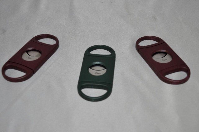 Zino Cigar Cutters, 3 Pieces: Zion Self-Sharpening Double Blade Cutters, (2) Crimson, (1) Green, Measurements: 3 1/2" x 1 1/2"