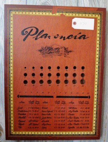 Wall Décor, 2 Pieces: (1) Nat Sherman Wall Clock, Featuring 2 Cigar Store Indians, 17 1/2" x 22 1/4" x 3", (1) Plasencia Cigar Sizer, 23 1/2" x 17" x 1 1/2"