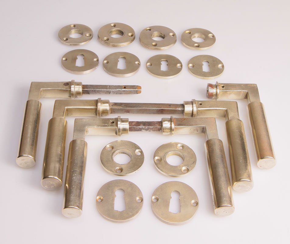 Drei Türdrückergarnituren: Metall, vernickelt. Drei je zweiteilige Türdrückergarnituren mit sechs Rosetten und sechs Schlüssellochrosetten. L. 11,1 cm. Walter Gropius Entwurf: 1922 Die Metallwerkstatt am Bauhaus, Ausst.kat.B