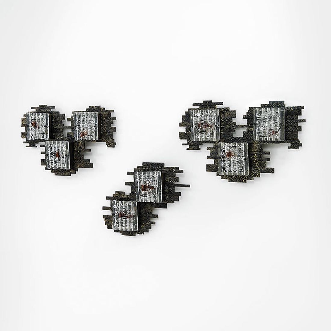 Angelo Brotto: Tre lampade da parete Metallo patinato e graffiato, vetro lavorato a caldo. Prod. Esperia, 1970 ca. cm 43x71x15, cm 43x60x15