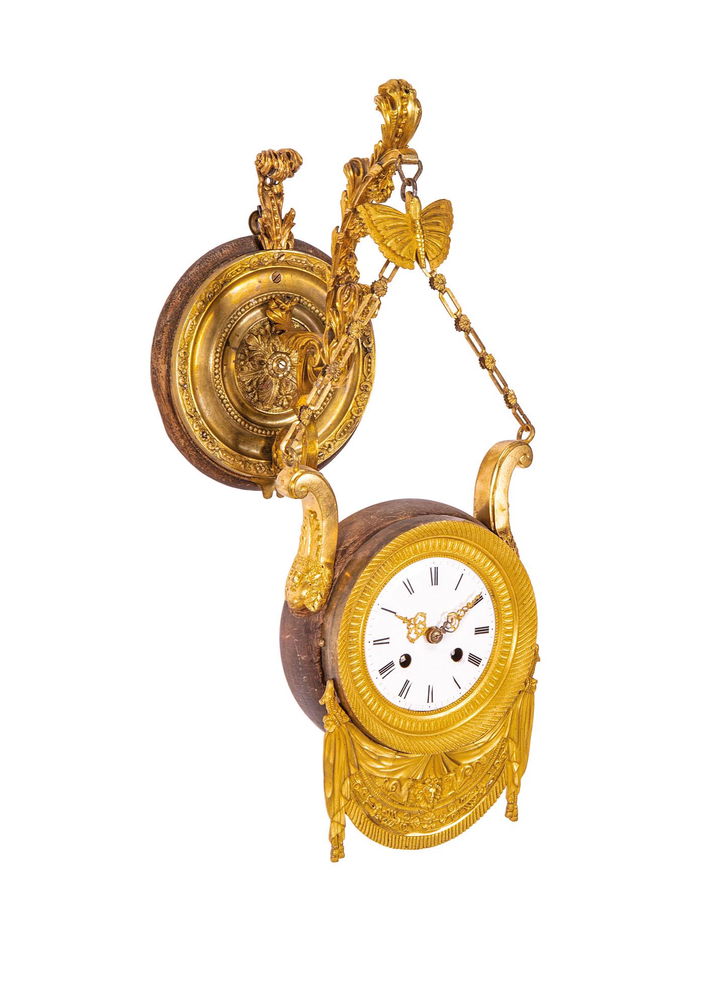 Orologio in bronzo: Orologio in bronzo costituito da una placca a muro da cui fuoriesce una catena con braccetto a sostegno dell'orologio. Epoca XIX secolo cm 48x20x25