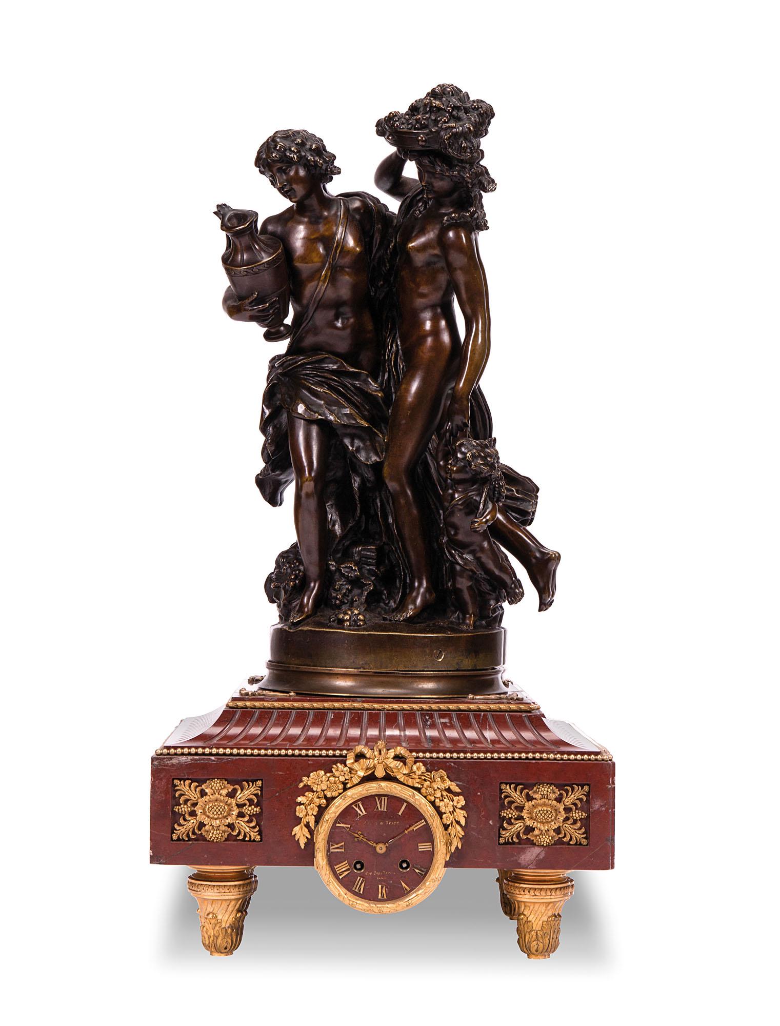 Orologio in marmo con sovrastante scultura in bronzo: Orologio in marmo con sovrastante scultura in bronzo raffigurante l'Allegoria del'Autunno. Bronzo firmato Clodion sulla base. Epoca XIX-XX secolo cm 80x38x30
