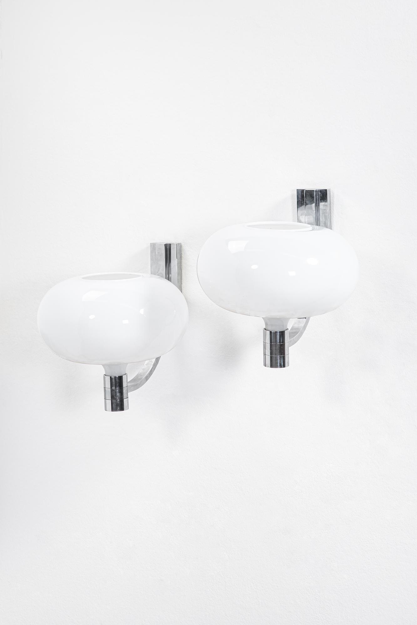 Franco Albini, 1905-1977. Coppia di lampade da parete: Coppia di lampade da parete della serie AM/ASMetallo cromato, vetro opalino.Prod. Sirrah, 1968Marchio del produttore sulle lampade.cm 47x40x50
