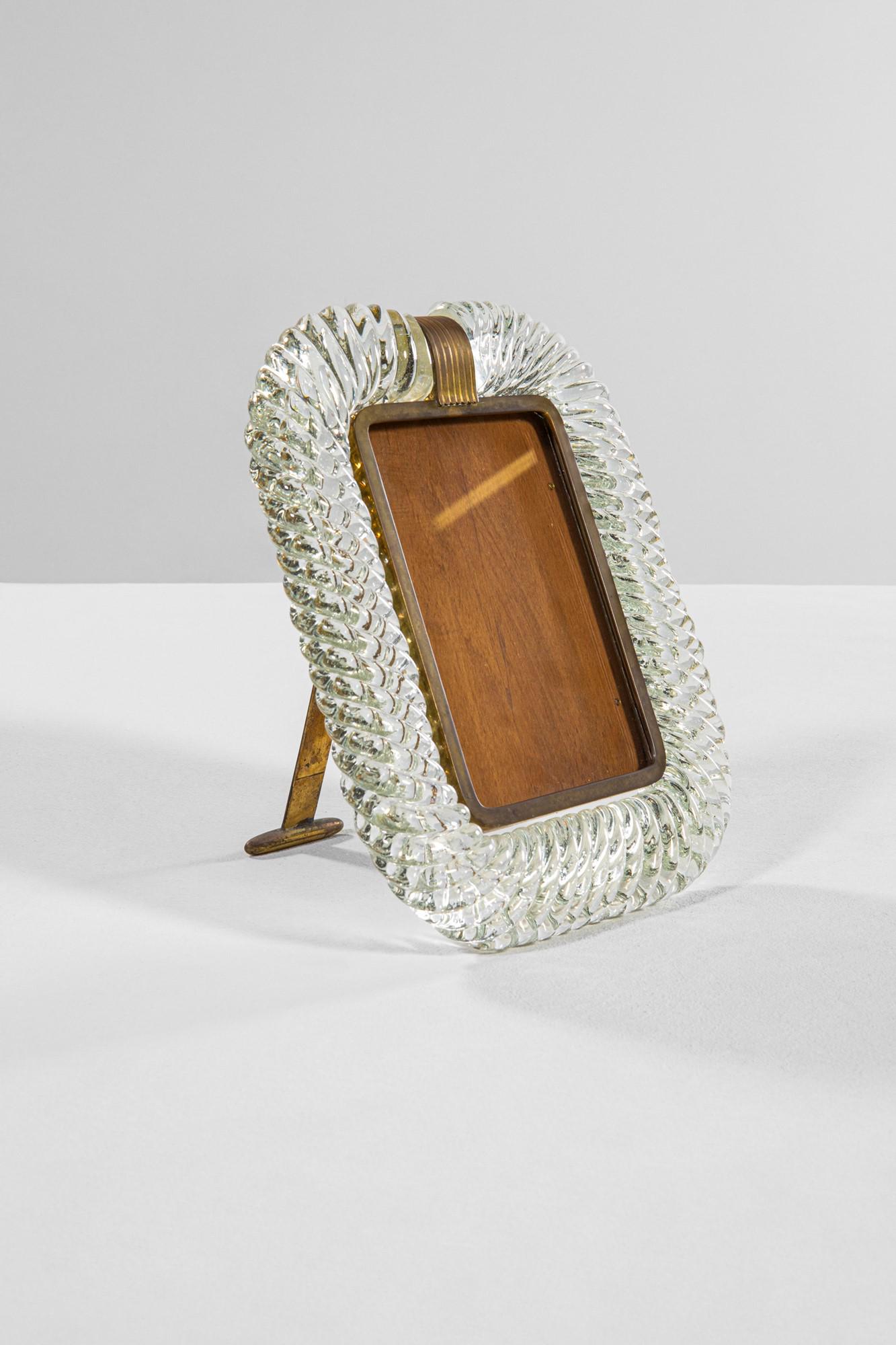 Barovier & Toso: Cornice portafoto da tavoloVetro cordonato trasparente, ottone.Prod. Barovier & Toso, anni '40Marchio inciso del produttore sul piedistallo.cm 25,5x23x19