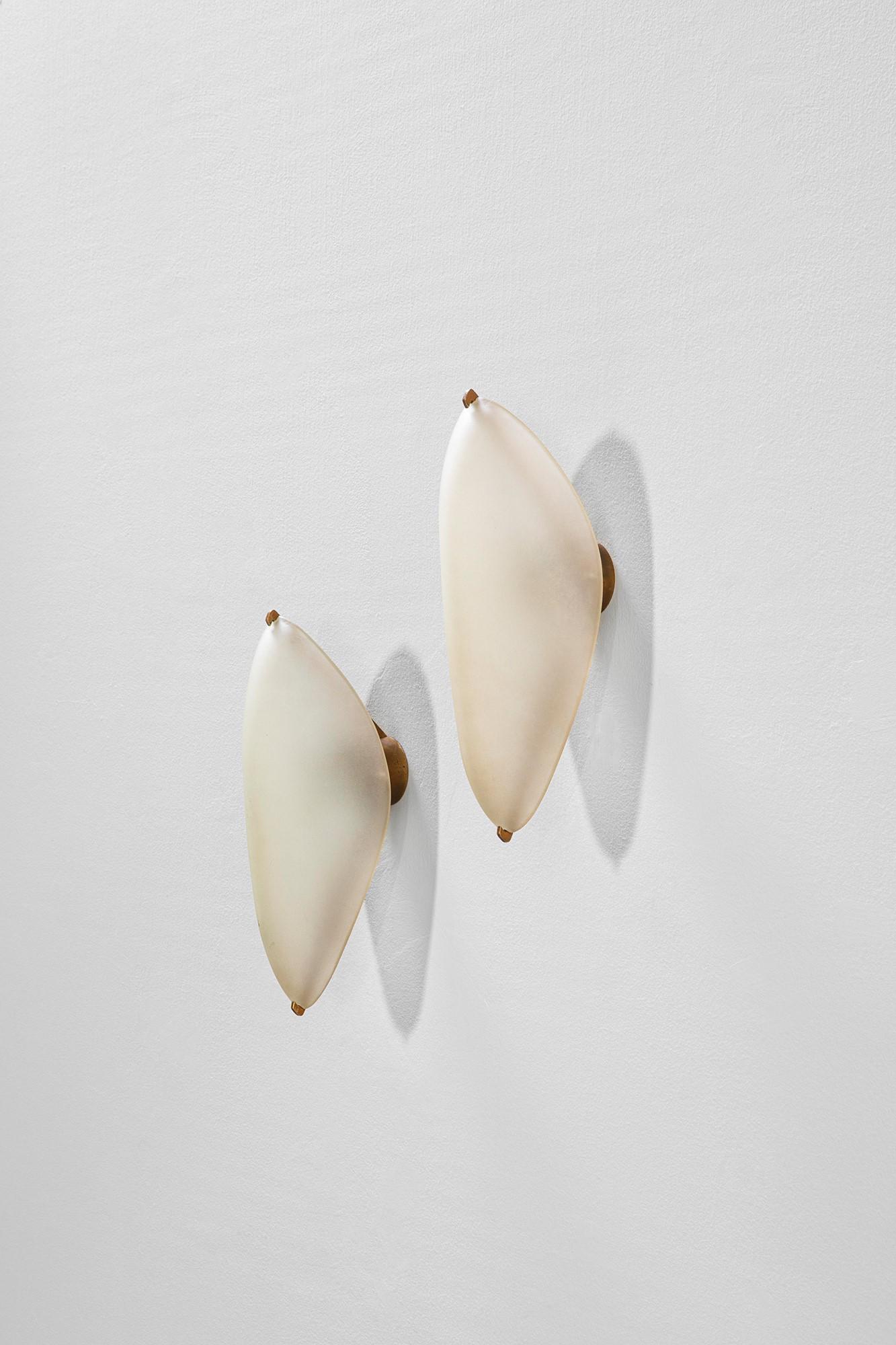 Max Ingrand: Coppia di lampade da parete mod. 2024Vetro curvato satinato, ottone.Prod. Fontana Arte, 1955 ca.cm 35x13x15LITERATURE:Quaderni Fontana Arte n. 1, p. 60.