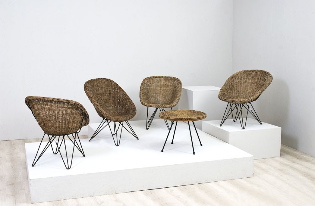 Quattro poltrone: Quattro poltrone nello stile di Charles e Ray Eames Gambe a traliccio in tondino metallico curvato, saldato e laccato, seduta a pozzetto in midollino intrecciato su struttura di metallo. Italia, fine 