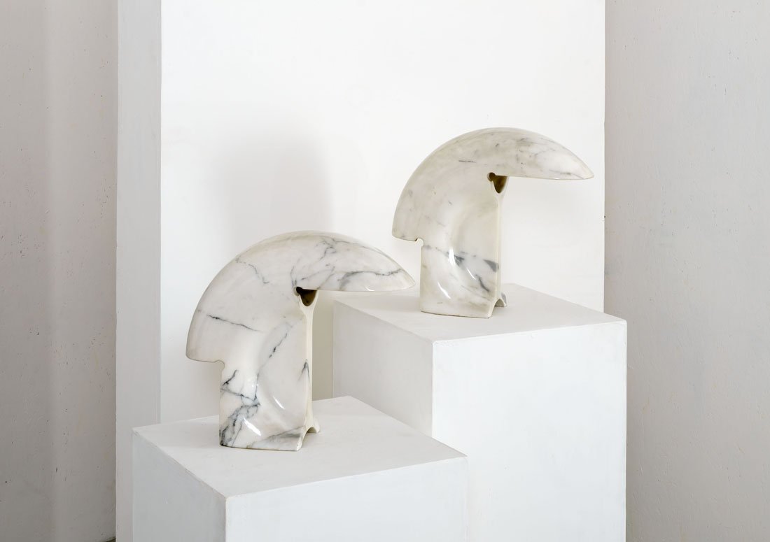 Tobia Scarpa: Coppia di lampade da tavolo mod. Biagio Blocco di marmo scolpito e fresato. Prod. Flos, 1968 Etichetta adesiva del produttore su una lampada. cm 33x39 Literature: G. Gramigna, Repertorio del design it