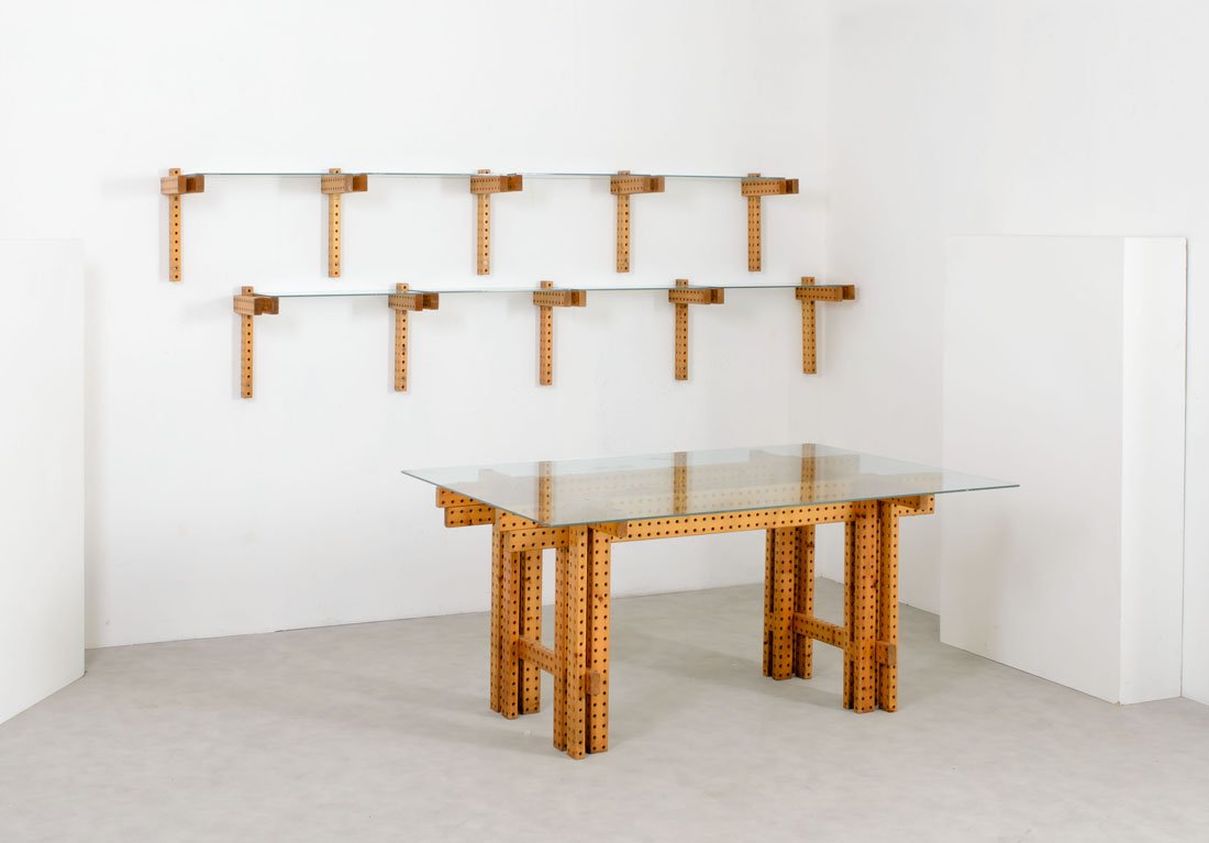 Leonardo Mosso (attr.): Tavolo e libreria pensile Legno di larice traforato, piano del tavolo e mensole realizzati con una lastra di vetro armato e molato. Torino, anni '70 Tavolo cm 75x162x120, mensole cm 43x63x32