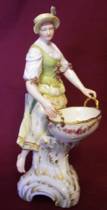 KPM Figurine: KPM Figurine of Young Lady with Basket, Marked with the KPM Sceptre and a More Recent KPM Mark, 8 3/4" Tall x 4" Across, Estimate: $200- $300