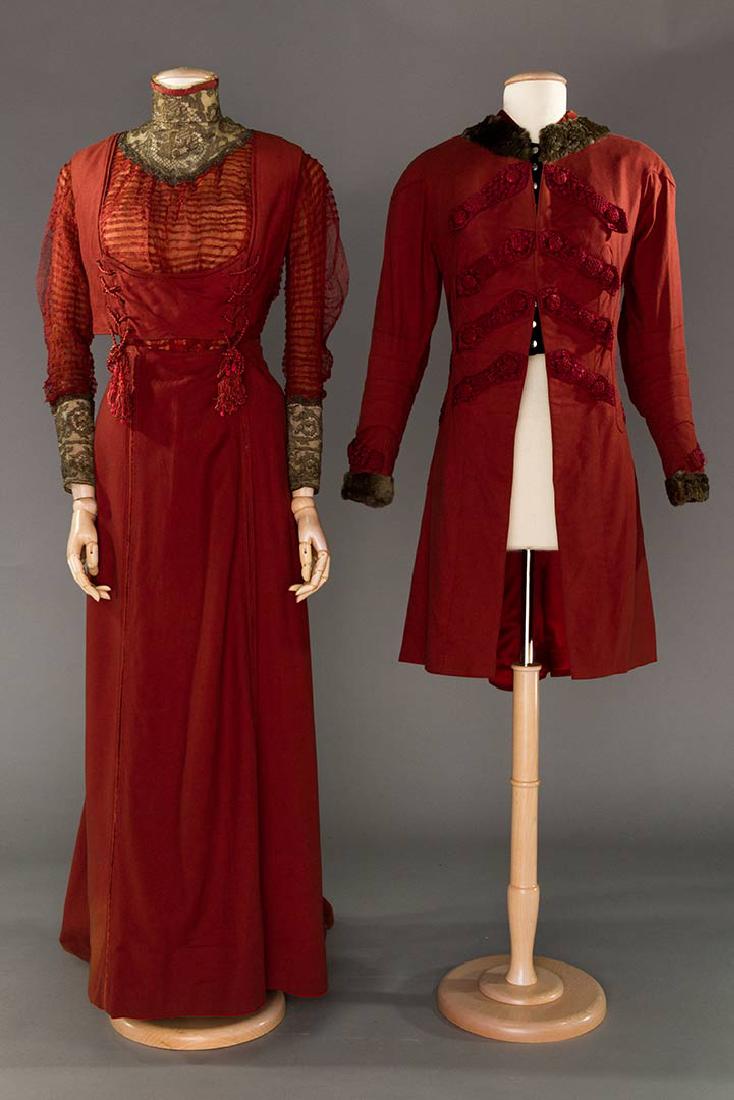 COUTURE PAQUIN WALKING SUIT, "CARLOMAN", WINTER, 1908: 3-piece, wine wool flannel, elongated jacket w/ military style silk cord & tassel trim & buttons, dark grey fur collar & cuffs, faux black velvet vest, pin-tucked silk mesh bodice, laced wool bib, pew