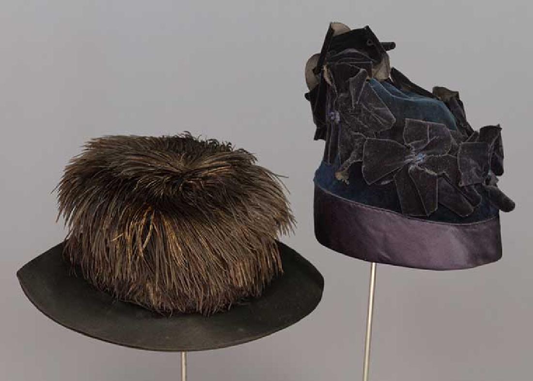 TWO LADIES' BLACK HATS, 1913-1918: 1 black velvet toque, angeled high crown to back, black velvet poppy blossom trim, gold stamped label "Bonwit Teller & Co.", excellent; 1 ovoid wide brim black satin hat, flat top round crown w/ black