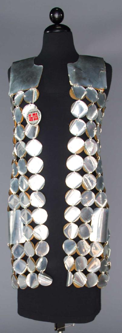 SILVER METALLIC LONG VEST, 1960s: Deadstock, Italian label "Gita", silver vinyl discs joined by silver jump rings, glued to matte black pleather discs, L 32", (disc edges coming unglued, small tears to yoke) very good.