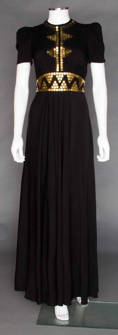 BRASS TRIMMED BLACK GOWN, c. 1938: Black silk crepe, square brass studs at W & B, short sleeves, back W tie, B 34", W 28", L 58", (top zipper stop missing, small stain on back hem) excellent.